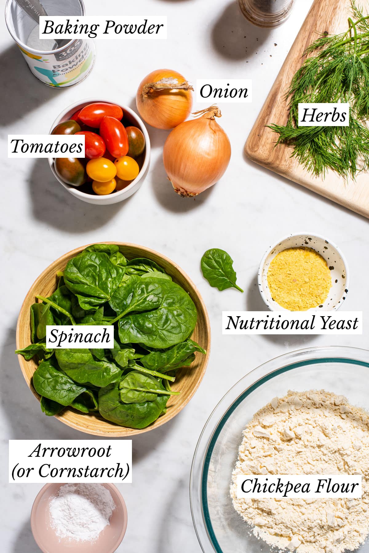 Ingredients gathered on a marble table to make a vegan chickpea flour frittata.