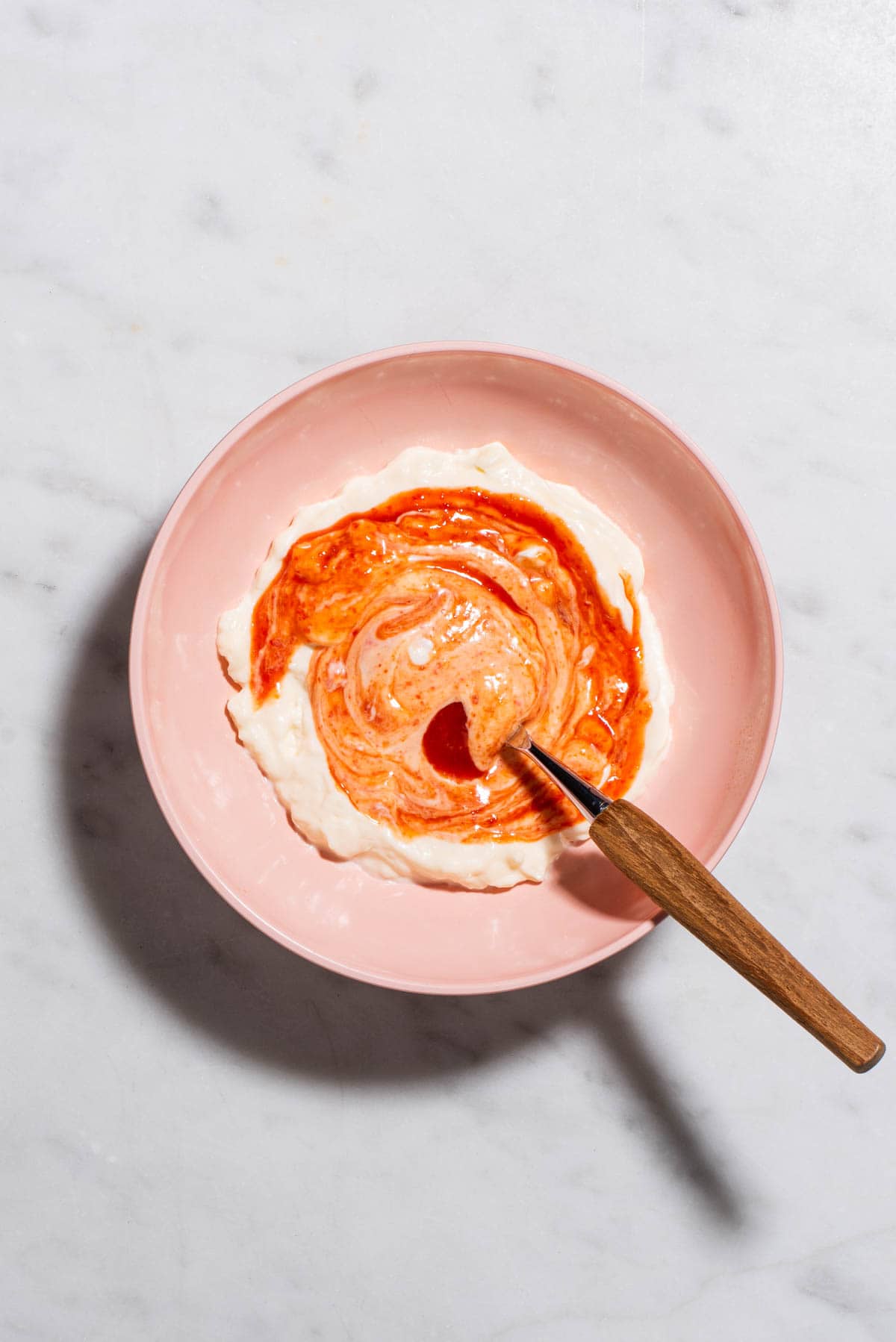 Homemade spicy mayo in a pink bowl.