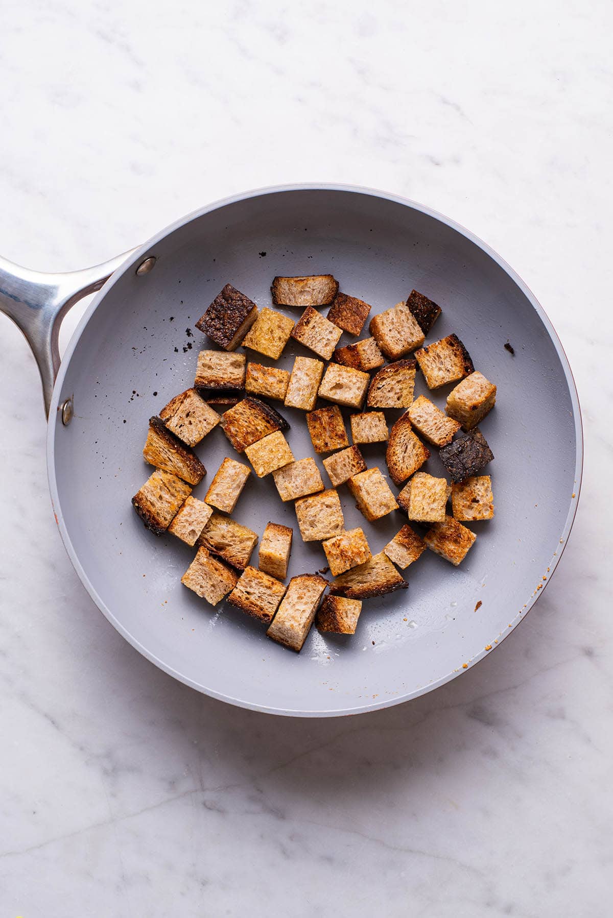 Homemade whole wheat croutons in a skillet.