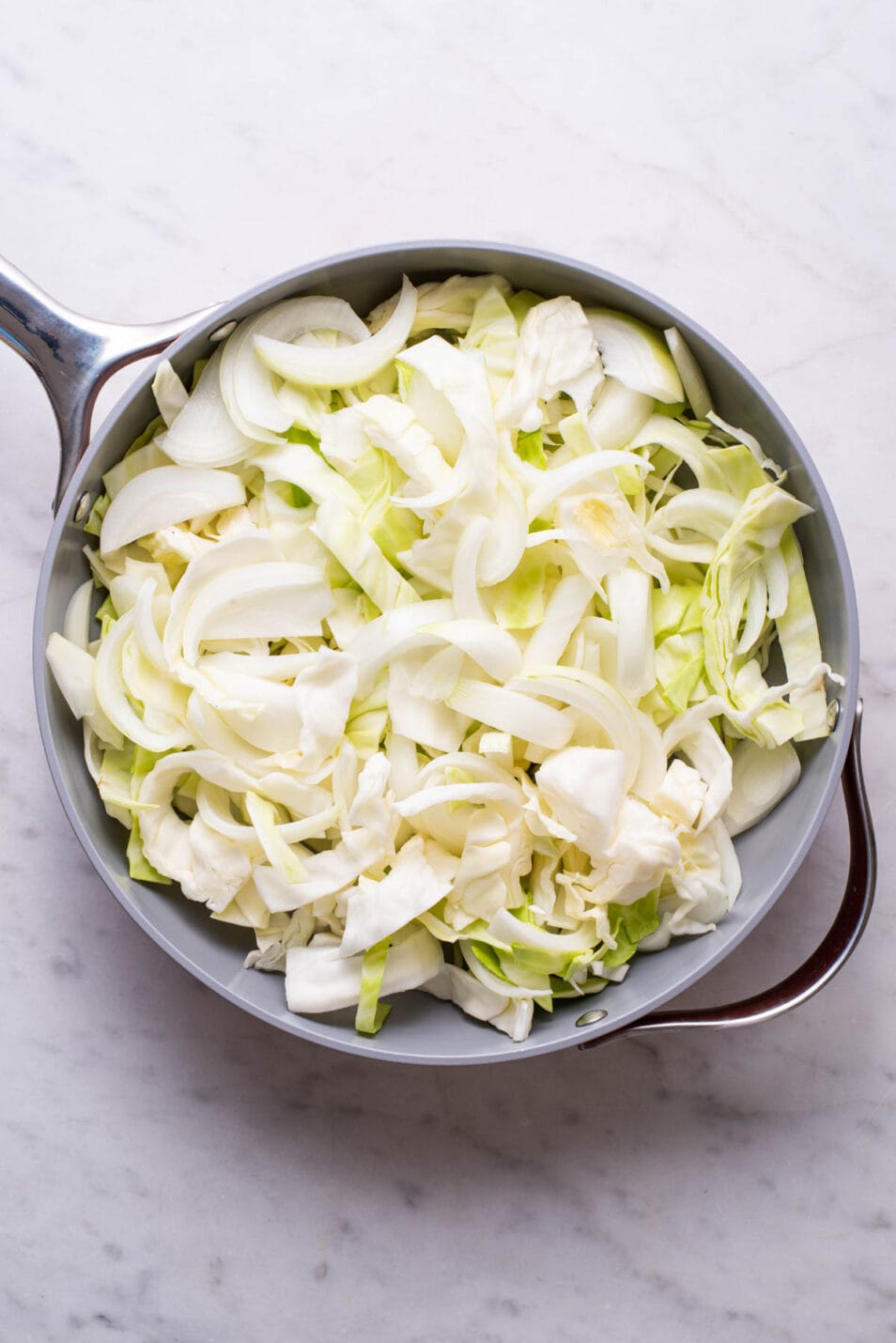 Chopped cabbage and onions in a large skillet.