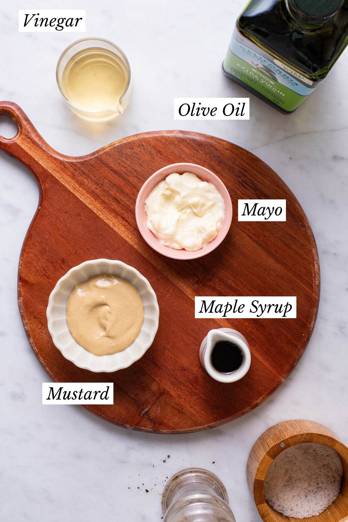 Ingredients to make creamy salad dressing gathered on a marble table.