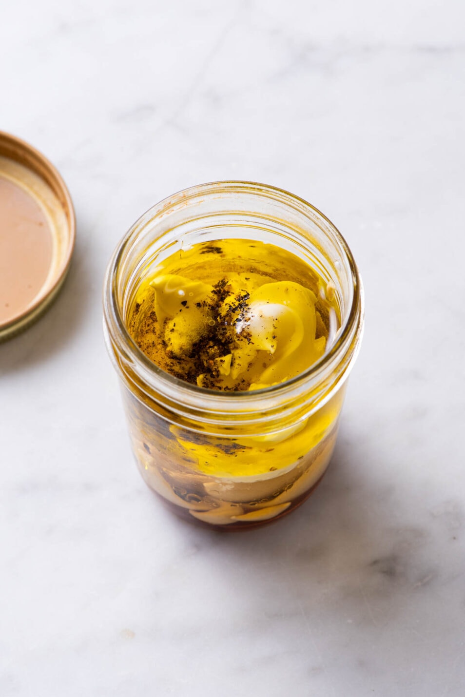 Ingredients to make creamy vinaigrette combined in a mason jar.