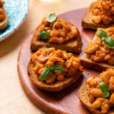 Tuscan beans on whole wheat toasts garnished with basil.