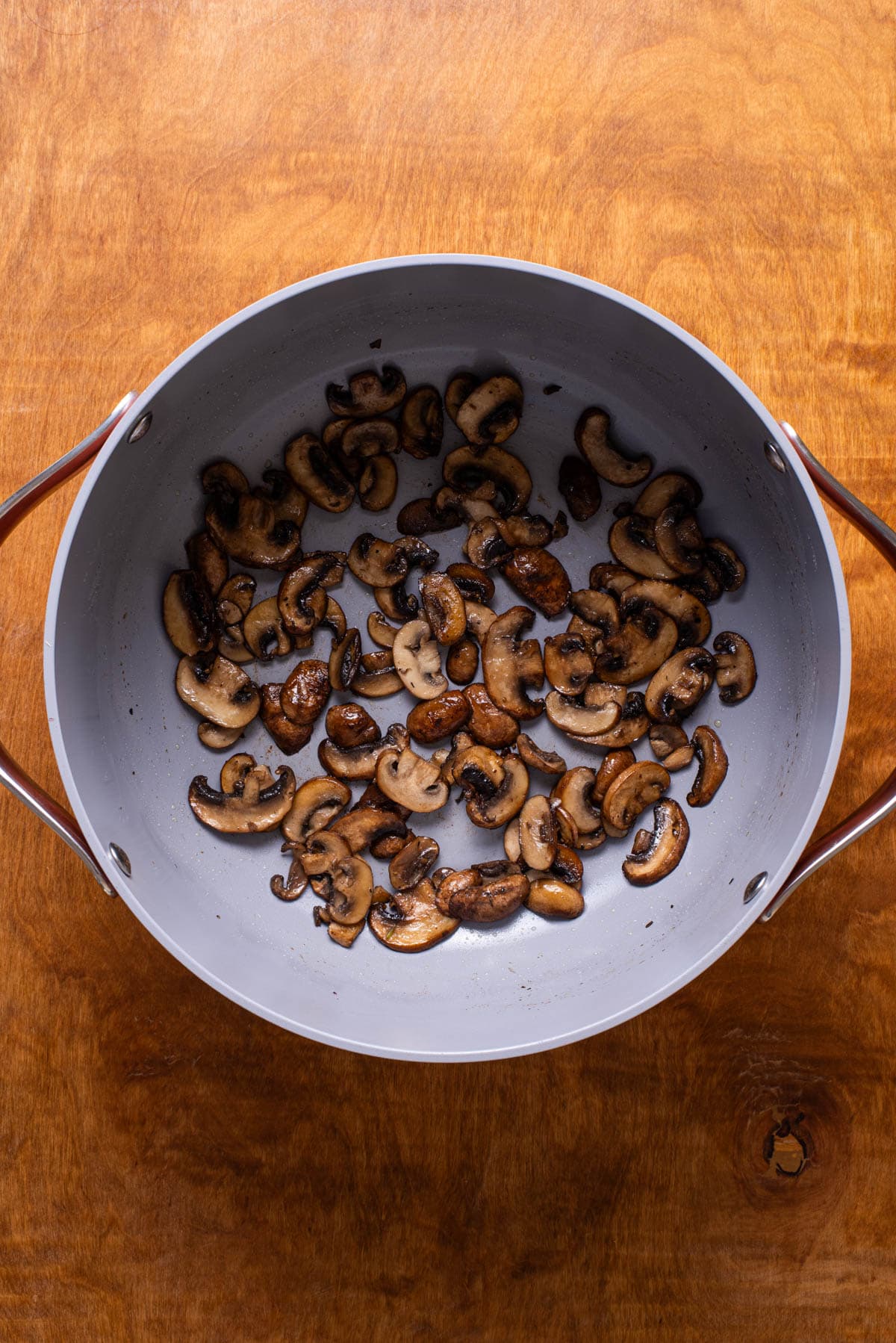 Sauteed sliced mushrooms in a Dutch oven.