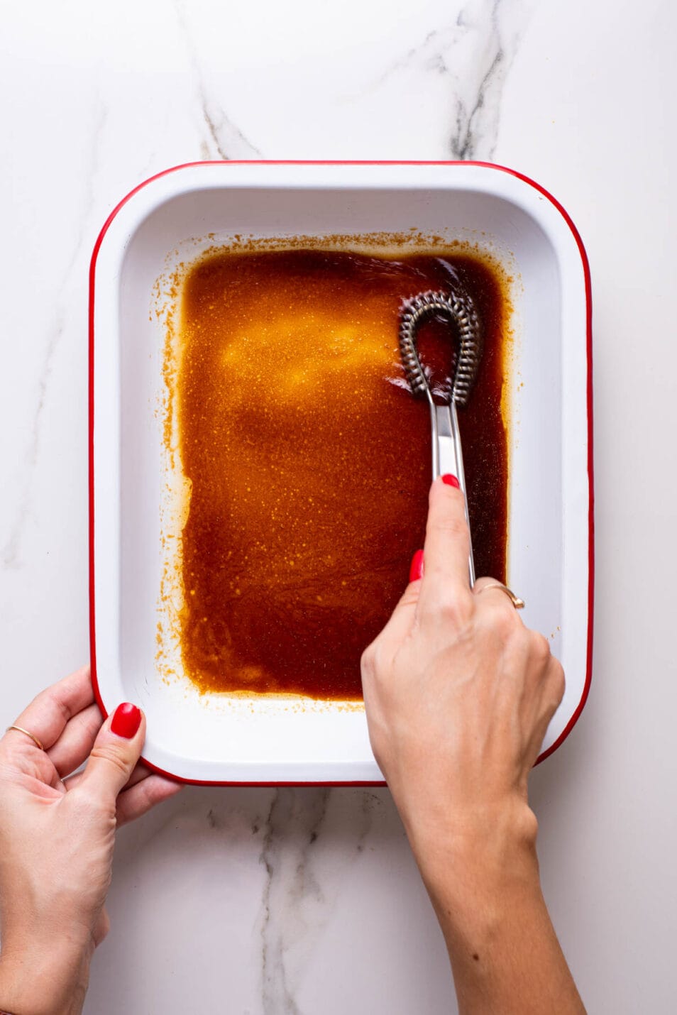 Whisking soy sauce marinade in a shallow dish.