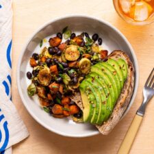 Sweet potato and Brussels sprout hash in a bowl with avocado toast.