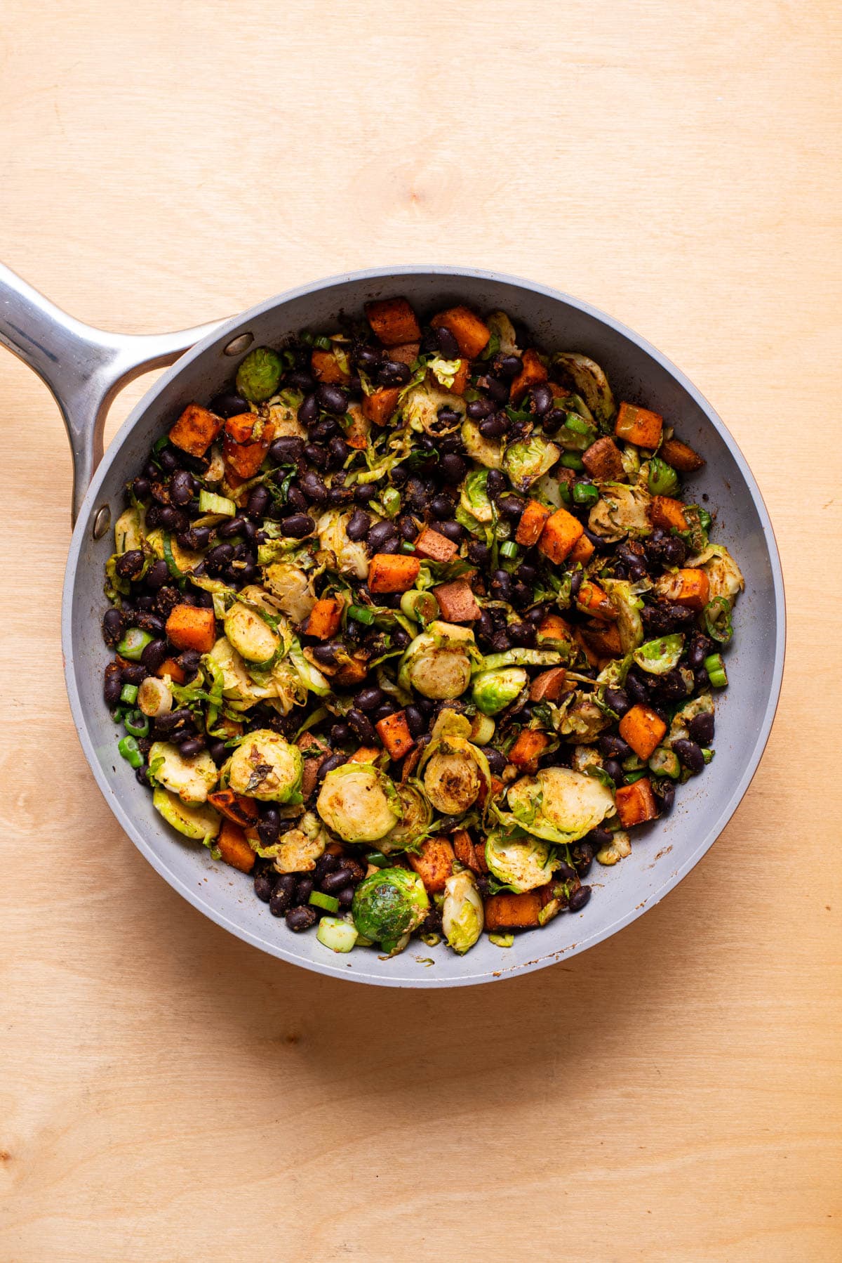 Vegan breakfast hash with vegetables and black beans in a skillet.
