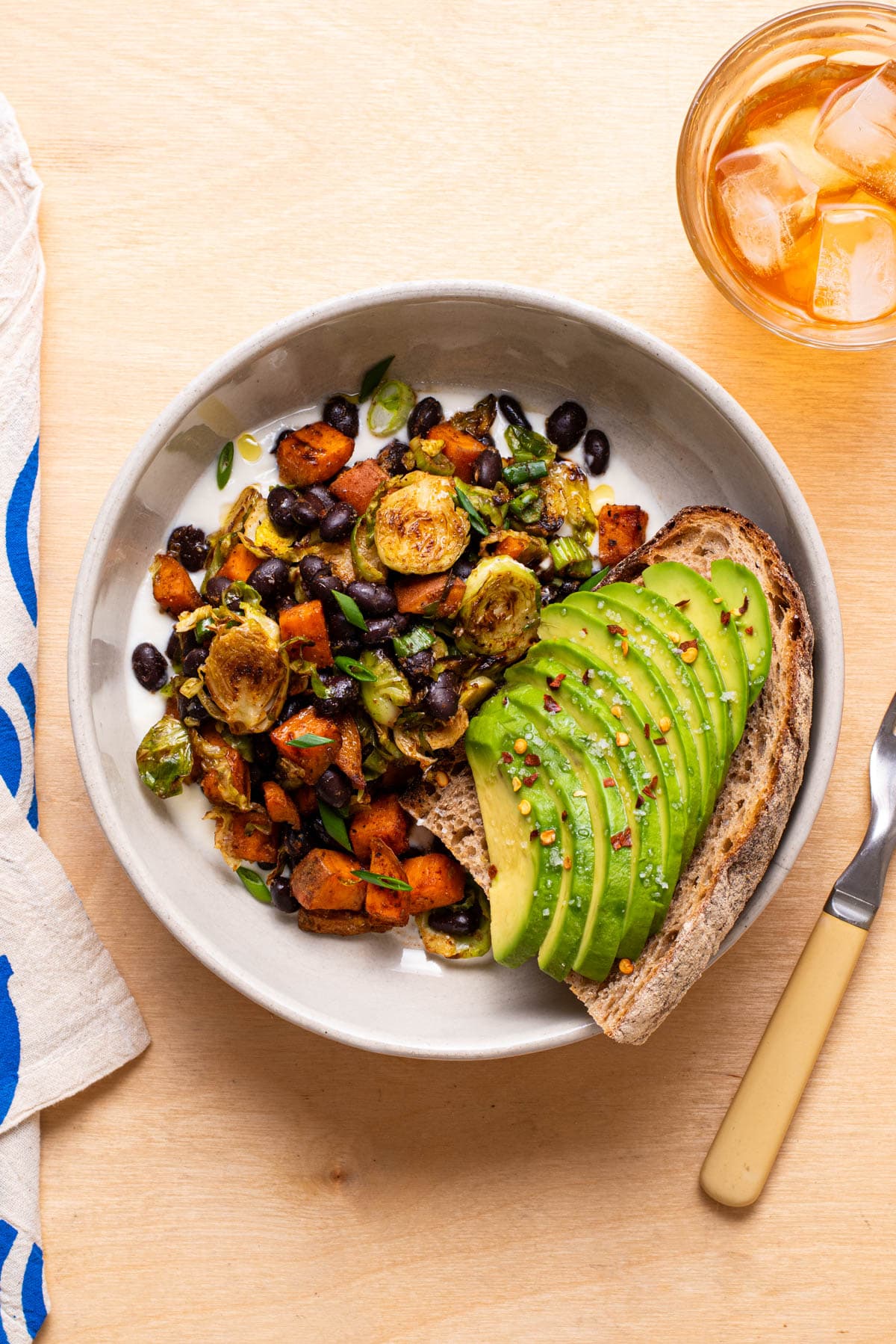Sweet potato and Brussels sprout hash in a bowl with avocado toast.