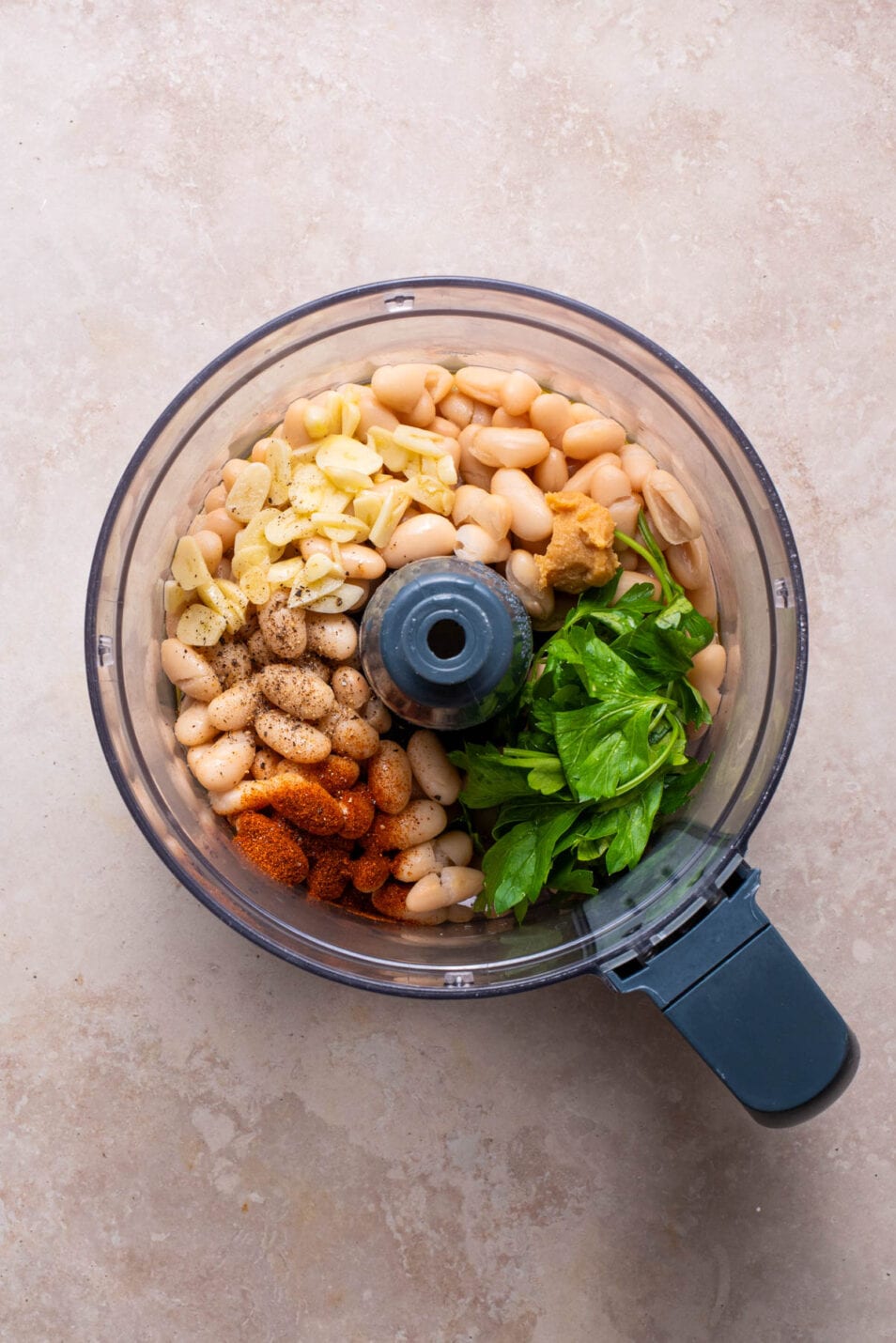 Ingredients to make cannellini bean dip combined in a food processor.