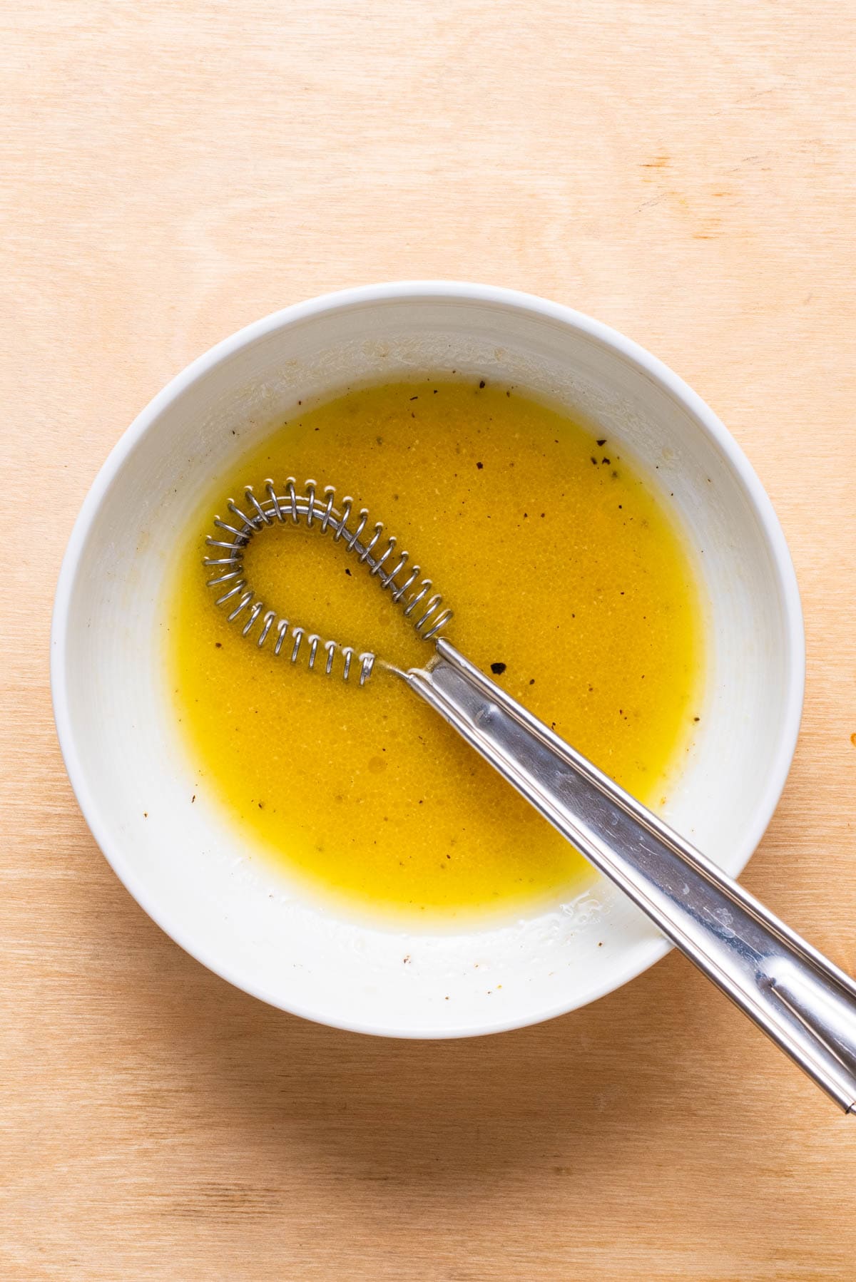 Salad dressing whisked in a bowl.