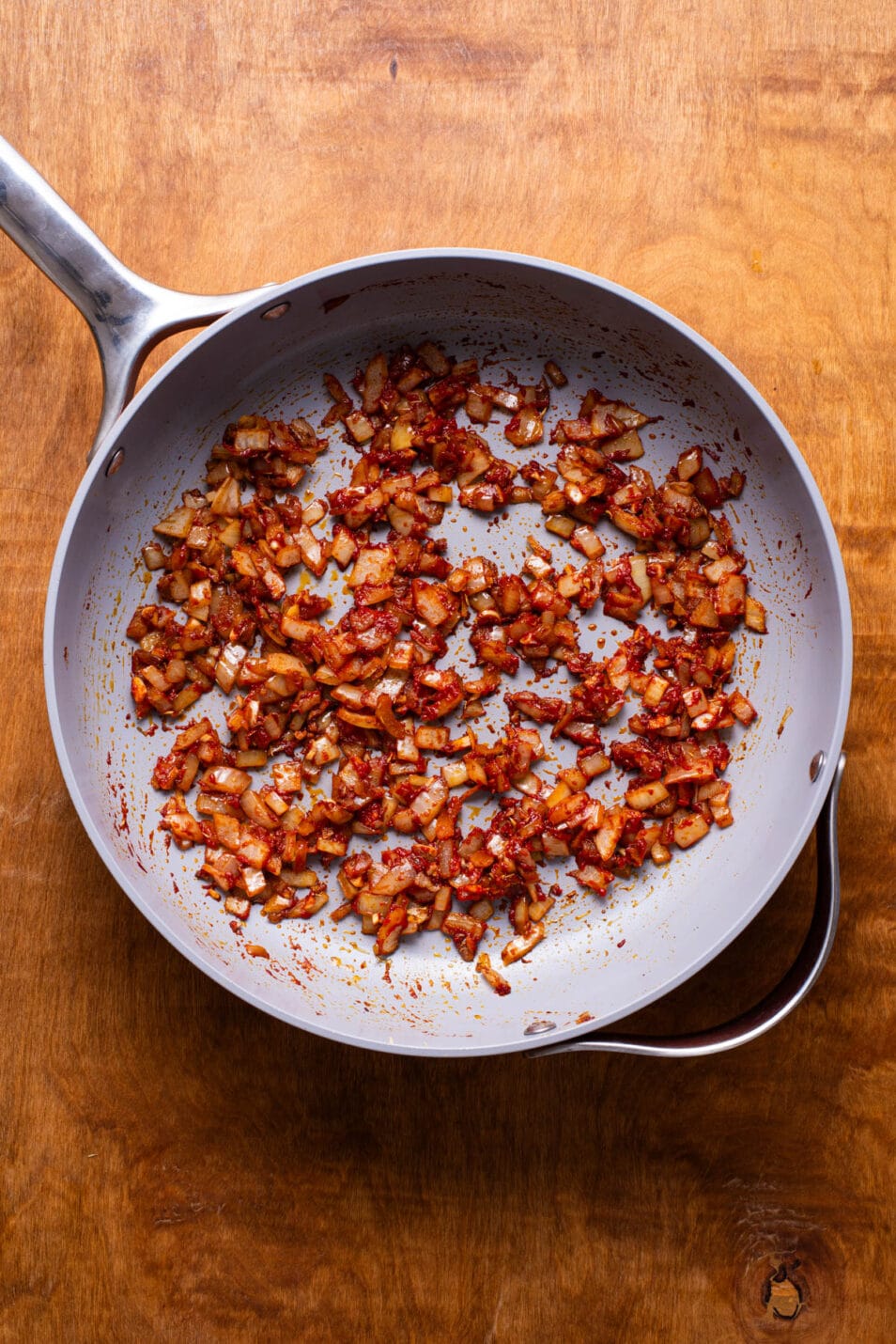 Sauteed onions with tomato paste in a skillet.