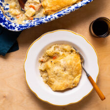 Vegan cauliflower pot pie with puff pastry, served in a vintage scalloped plate.