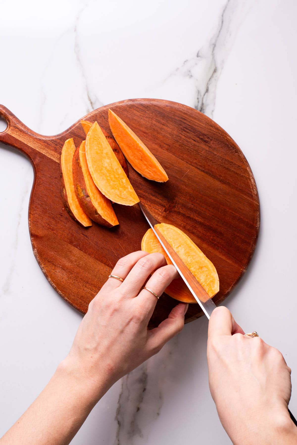Cutting sweet potatoes into wedges.