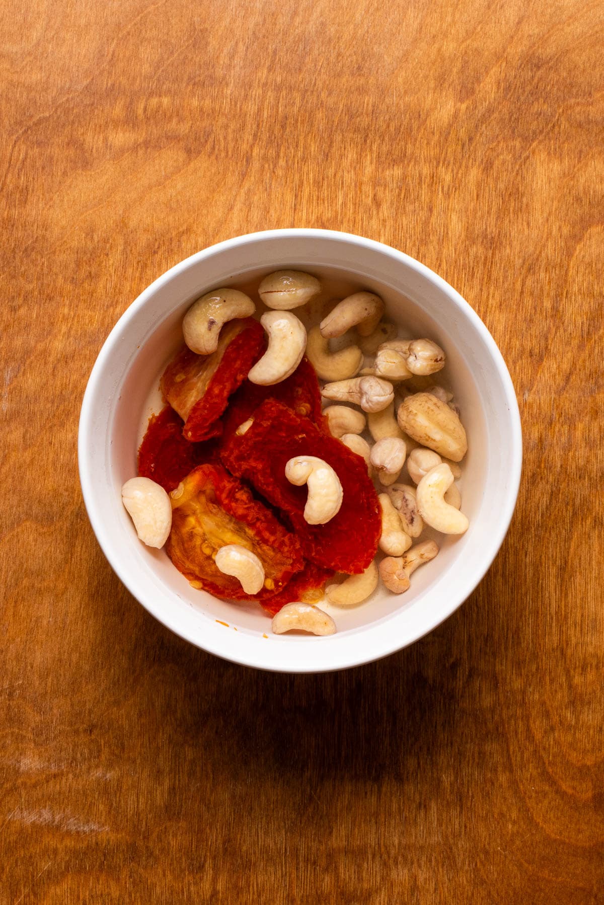 Soaking sun-dried tomatoes and cashews in a bowl of water.