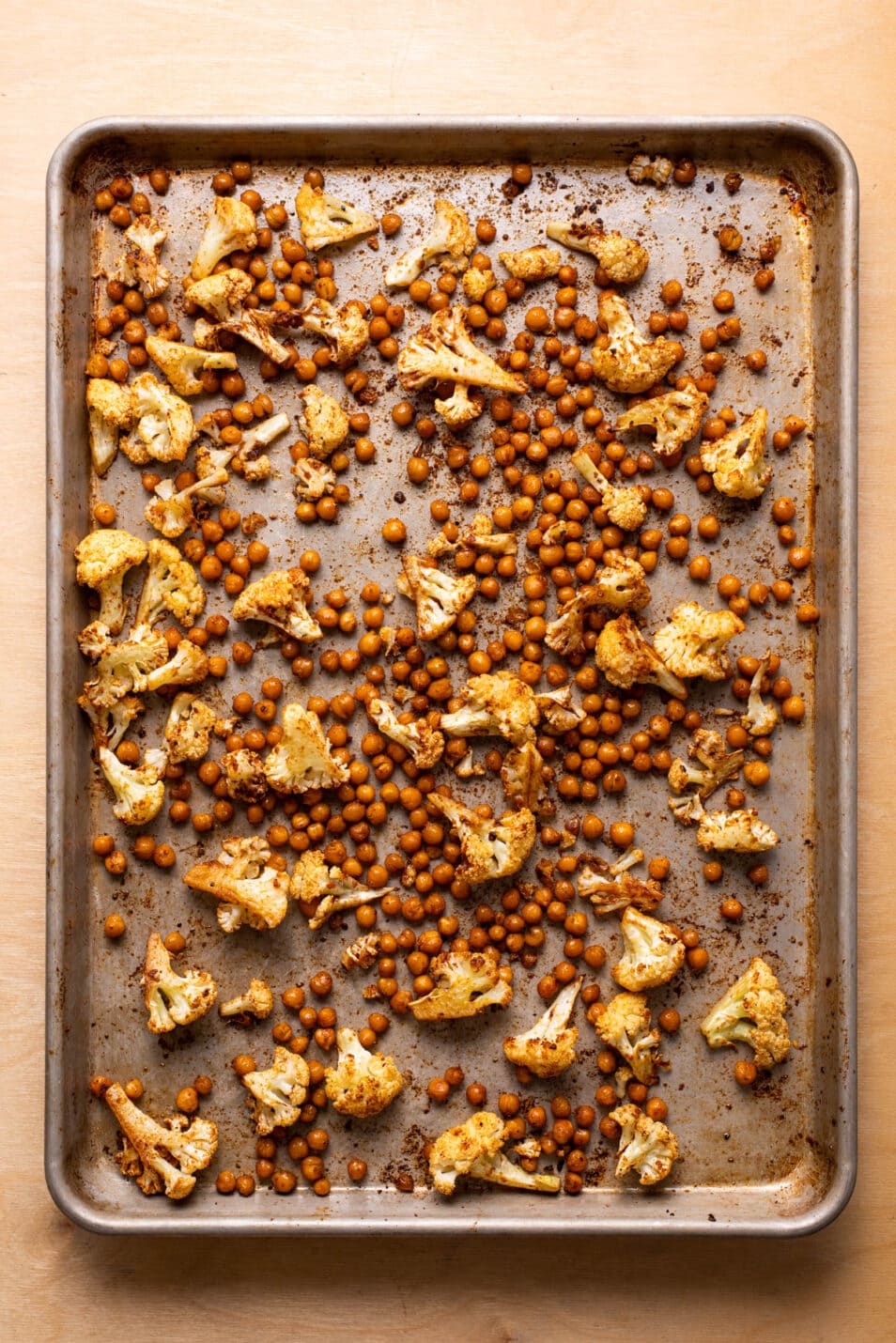 Roasted cauliflower and chickpeas on a baking sheet.