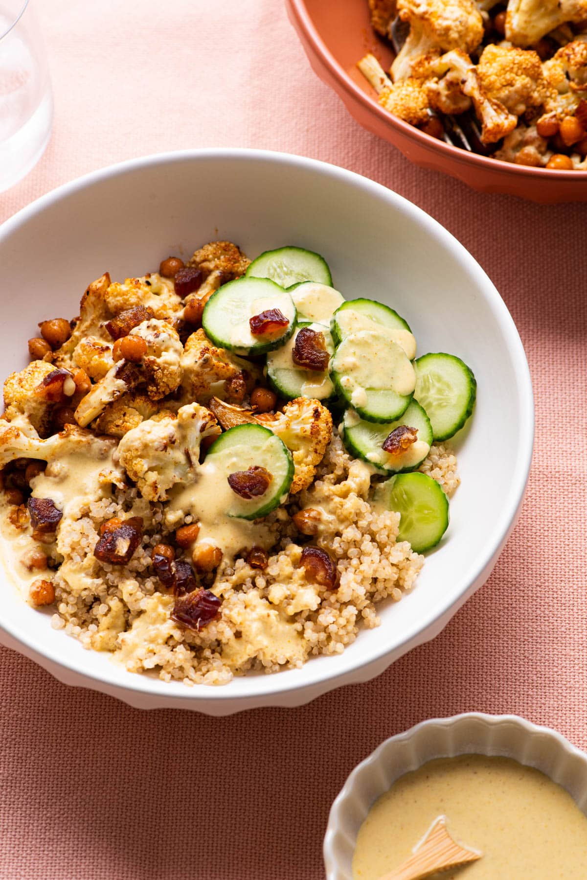 Roasted cauliflower and chickpea quinoa bowls with tahini dressing, cucumbers, and dates.