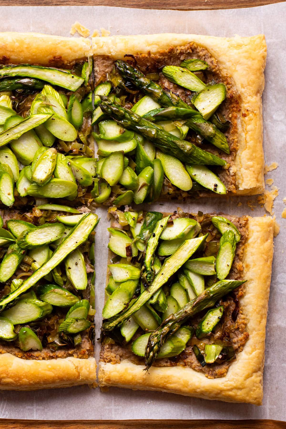 Savory vegan puff pastry tart topped with sliced asparagus.