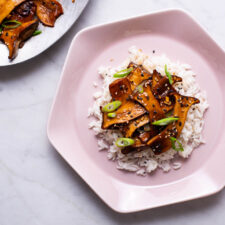 Soy-glazed trumpet mushrooms on white rice with scallions.