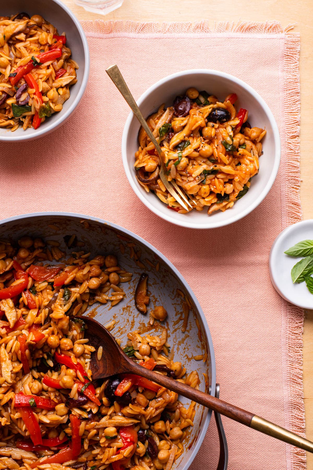 Tomato baked orzo in a large skillet and bowls.