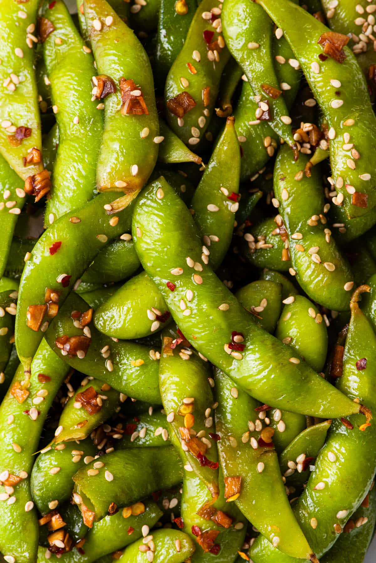 Cooked edamame pods coated in a garlic, ginger, and sesame mixture.