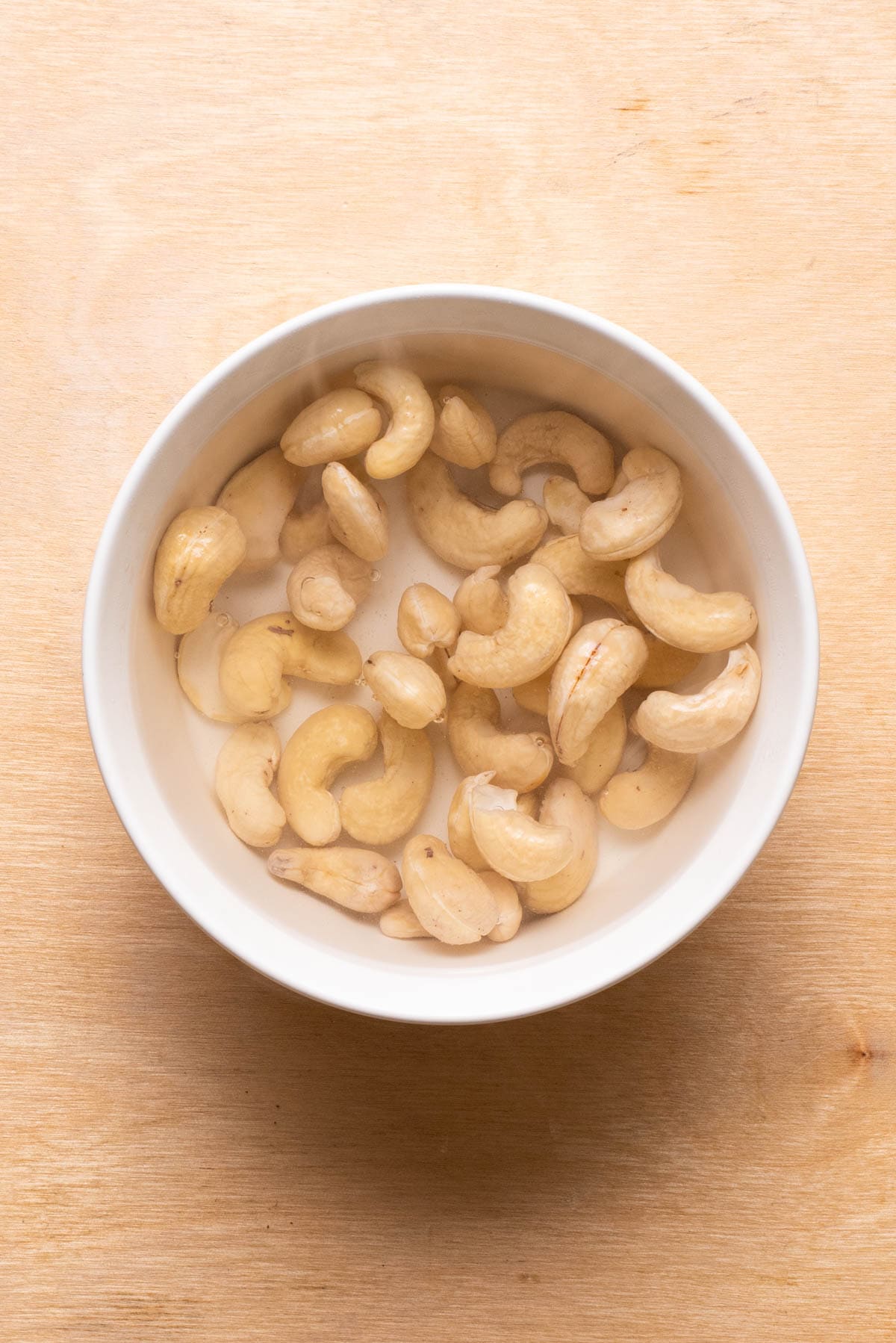 Raw cashews soaking in boiling water.
