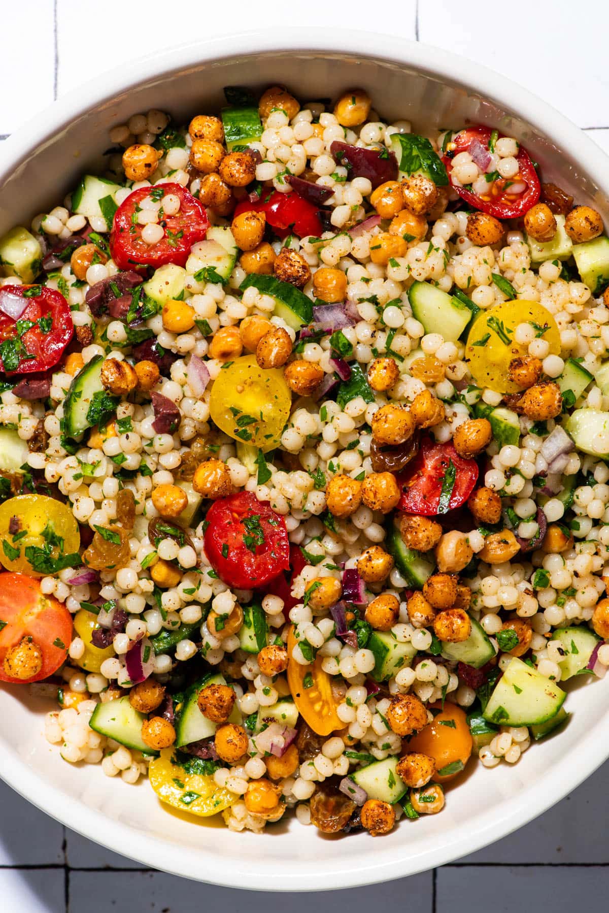 Vegan pearl couscous salad with chickpeas and raisins.