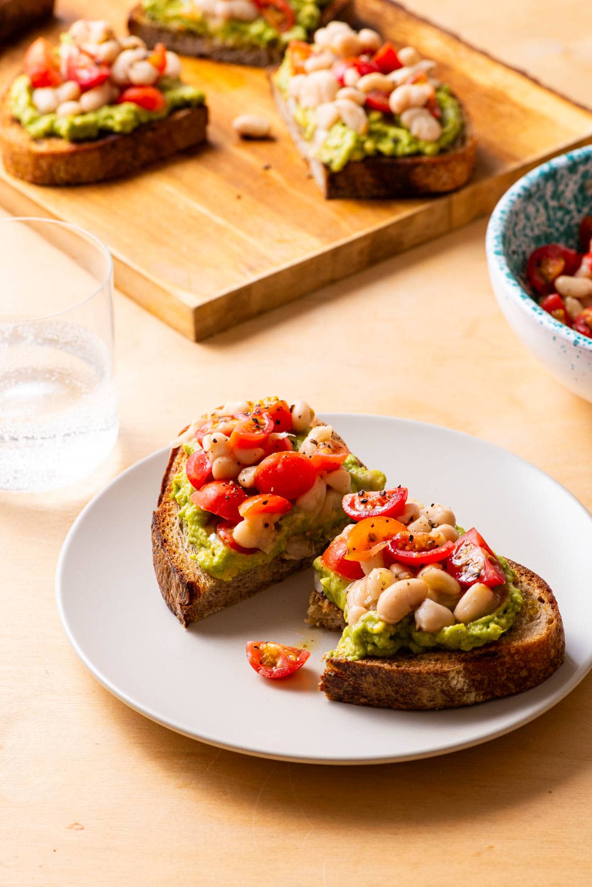 Avocado tomato bruschetta with white beans, on sourdough toast.